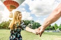 Happy young woman wants to make balloon tour holding boyfriend`s hand - Follow me, future together and love concept - Couple of