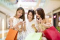 Happy young woman watching smart phone in shopping mall Royalty Free Stock Photo