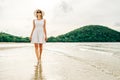 Happy young woman wearing beautiful white dress walking on the beach Royalty Free Stock Photo