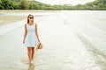 Happy young woman wearing beautiful white dress walking on the beach Royalty Free Stock Photo