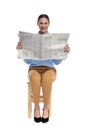 Happy young woman reading newspaper and smiling Royalty Free Stock Photo