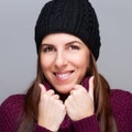 Happy young woman wearing cap and smiling on light Royalty Free Stock Photo