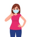 Happy young woman wearing medical face mask and showing thumbs up sign. Trendy girl covering protective surgical mask