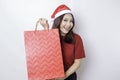 A happy young woman is wearing Santa Claus` hat and holding Christmas presents Royalty Free Stock Photo