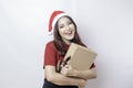 A happy young woman is wearing Santa Claus` hat and holding Christmas presents Royalty Free Stock Photo