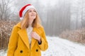 Happy young woman wearing a yellow coat, red hat smiling over nature background, trendy color of year 2021 - Royalty Free Stock Photo