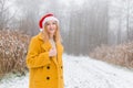 Happy young woman wearing a yellow coat, red hat smiling over nature background, trendy color of year 2021 - Royalty Free Stock Photo