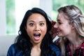 Happy young woman whispering to female friend Royalty Free Stock Photo