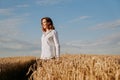 Happy young woman in a white shirt in a wheat field. Sunny day. Royalty Free Stock Photo
