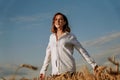 Happy young woman in a white shirt in a wheat field. Sunny day. Royalty Free Stock Photo