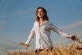 Happy young woman in a white shirt in a wheat field. Sunny day. Royalty Free Stock Photo