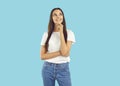 Happy young woman in white T shirt and blue jeans thinking or dreaming about something Royalty Free Stock Photo