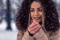 Happy woman in winter snow day blow on her cold hands