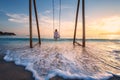 Happy young woman on wooden swing in water, sea with waves Royalty Free Stock Photo