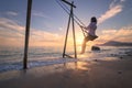 Happy young woman on wooden swing in water, sea with waves Royalty Free Stock Photo