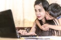 Happy young woman working and learning online from laptop. Mother and kid smile work from home concept Royalty Free Stock Photo