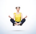 Happy young women in casual clothes meditating levitating in the air on light blue background. Comprehended relaxation Royalty Free Stock Photo