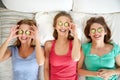 Happy young women with cucumber mask lying in bed Royalty Free Stock Photo