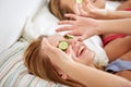 Happy young women with cucumber mask lying in bed Royalty Free Stock Photo