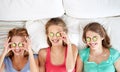 Happy young women with cucumber mask lying in bed Royalty Free Stock Photo