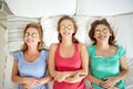 Happy young women with cucumber mask lying in bed Royalty Free Stock Photo