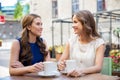 Happy young women drinking coffee at outdoor cafe Royalty Free Stock Photo