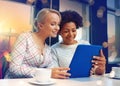 Happy young women drinking tea or coffee at cafe Royalty Free Stock Photo