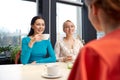 Happy young women drinking tea or coffee at cafe Royalty Free Stock Photo