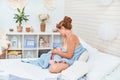 Happy young woman is breastfeeding while sitting and hugging her baby