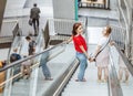 Young woman friends on escalator in shopping mall Royalty Free Stock Photo