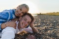 Happy young woman lying on her boyfriends back, looking at camera, having fun together. Royalty Free Stock Photo