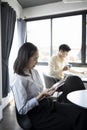 Happy young woman office worker take break in office with her colleague and using tablet. Royalty Free Stock Photo