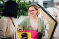 Happy young women with shopping bags and coffee paper cups sitting, resting and talking after shopping in mall Royalty Free Stock Photo