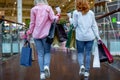 Happy young women with shopping bags enjoying in shopping, girls are having fun with their purchases. rear view Royalty Free Stock Photo