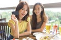 Happy young women showing the credit card in restaurant