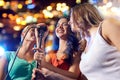 Happy young women singing karaoke in night club Royalty Free Stock Photo