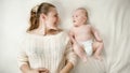 Happy young woman smiling at her little baby son on bed Royalty Free Stock Photo