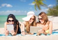 Happy young women with tablet pc on summer beach