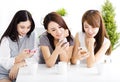 Happy young women watching smart phone in living room