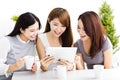 happy young women watching tablet in living room