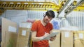 Happy young worker in industrial warehouse listening to music and dancing during work. Man in headphones have fun at Royalty Free Stock Photo