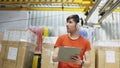 Happy young worker in industrial warehouse listening to music during work. Man in headphones have fun at workplace. Royalty Free Stock Photo