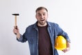 Happy young working man with hammer and hardhat Royalty Free Stock Photo