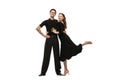 Two young graceful dancers wearing black stage outfits dancing ballroom dance isolated on white background. Concept of Royalty Free Stock Photo