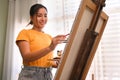 Happy young woman painting picture with watercolor at cozy home. Art, creative hobby and leisure activity concept Royalty Free Stock Photo