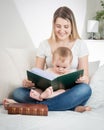 Happymother sitting on sofa at living room and reading book to h Royalty Free Stock Photo