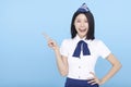 Happyrline stewardess pointing at something on blue background Royalty Free Stock Photo