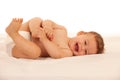 Hapy baby boy in playing on bed isolated over white Royalty Free Stock Photo