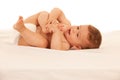 Hapy baby boy in playing on bed isolated over white