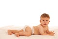 Hapy baby boy in playing on bed isolated over white